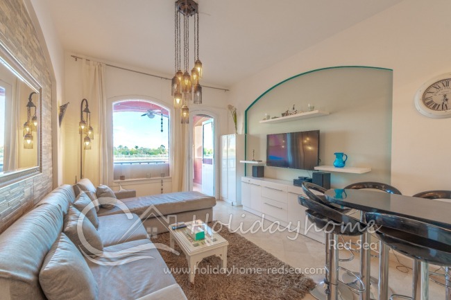 Living room with access to the balcony and a bar counter for dining