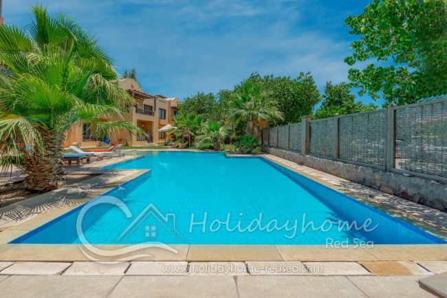 Shared pool with sun loungers and parasol