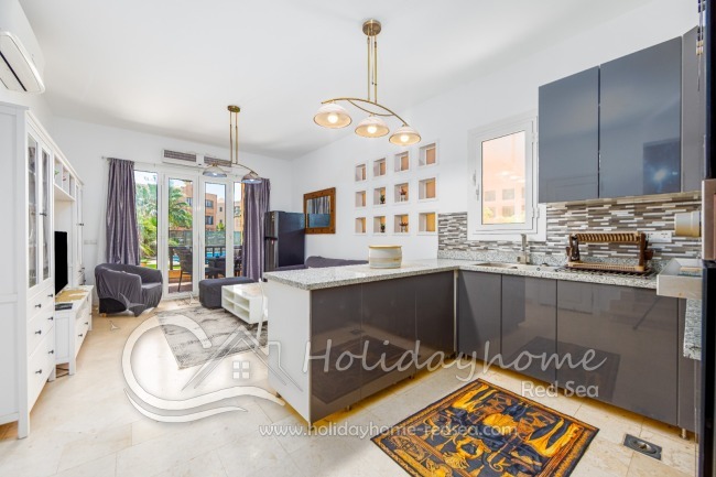 Open kitchen, with living/dining area and terrace to the pool. 