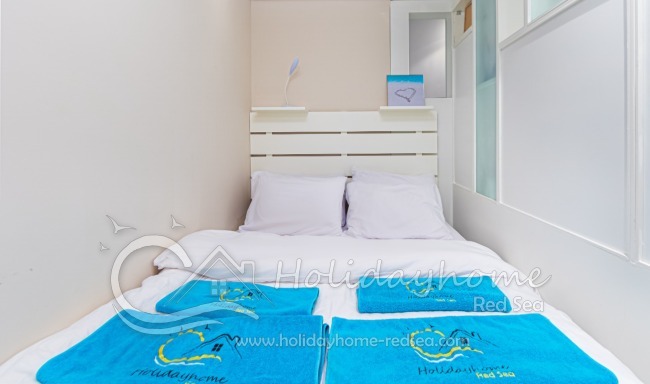 Small additional bedroom with bed and cupboard