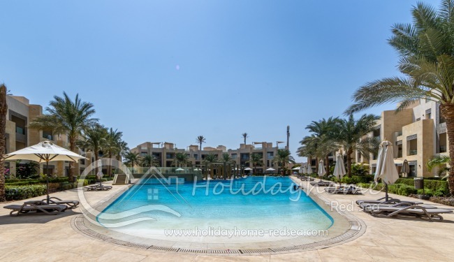 Large pool with sunbeds and umbrellas