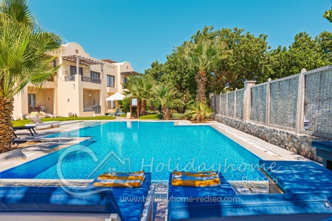 Shared pool with sun loungers and parasol