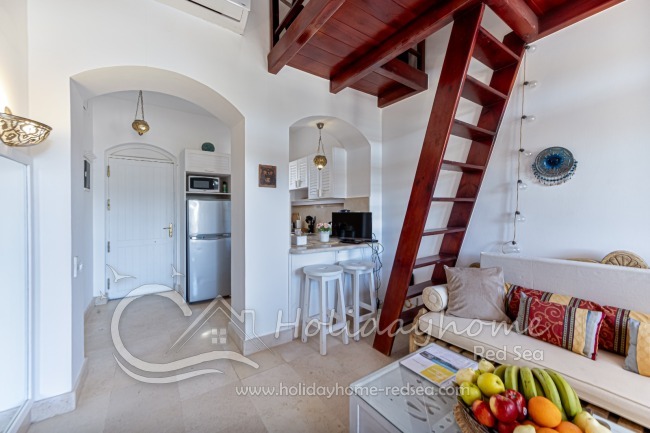 Open living room with kitchen and stairs to the platform 